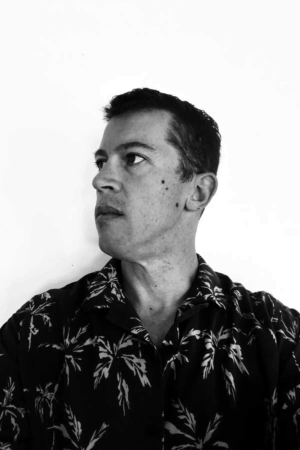 Black-and-white portrait of Bobby Meyer in a palm-print shirt, looking off to one side.